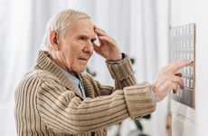 [Translate to Swiss:] Old man touching his forehead standing infront of an button panel