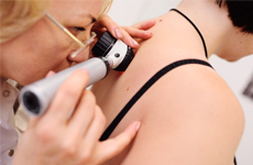 [Translate to Swiss:] Physician looking on skin of patient with an miscroscope instrument