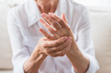 [Translate to Swiss:] Person in white blouse holding left hand with right hand